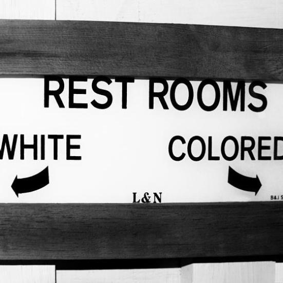 Toiletskilt der henviser til et toilet for hvide og et andet for sorte