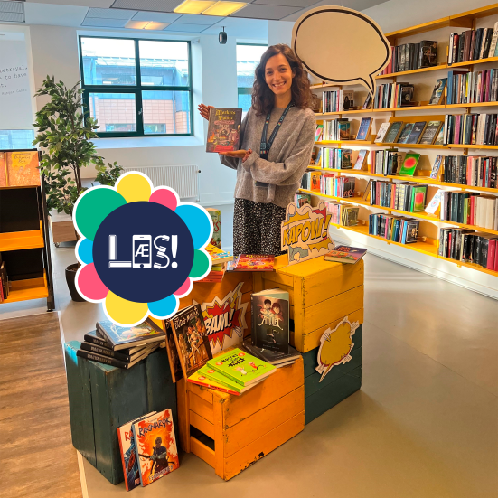 Bibliotekar står med bog i hånden og holder booktalk. 