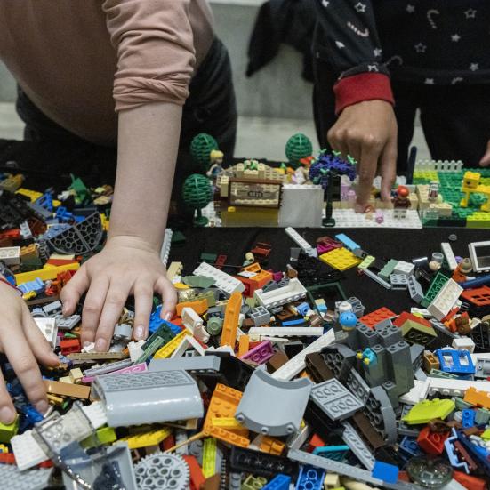 Børnehænder, der hygger med at bygge LEGO.
