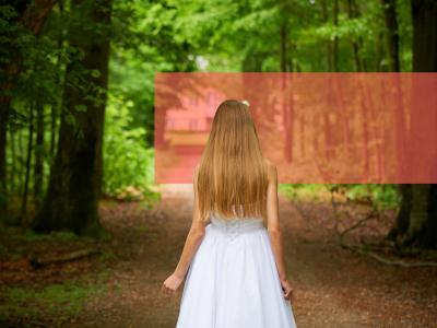 Konfirmand i hvid kjole på vej i bøgeskov